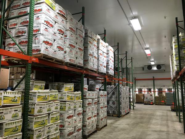 A food bank warehouse with boxes of produce.